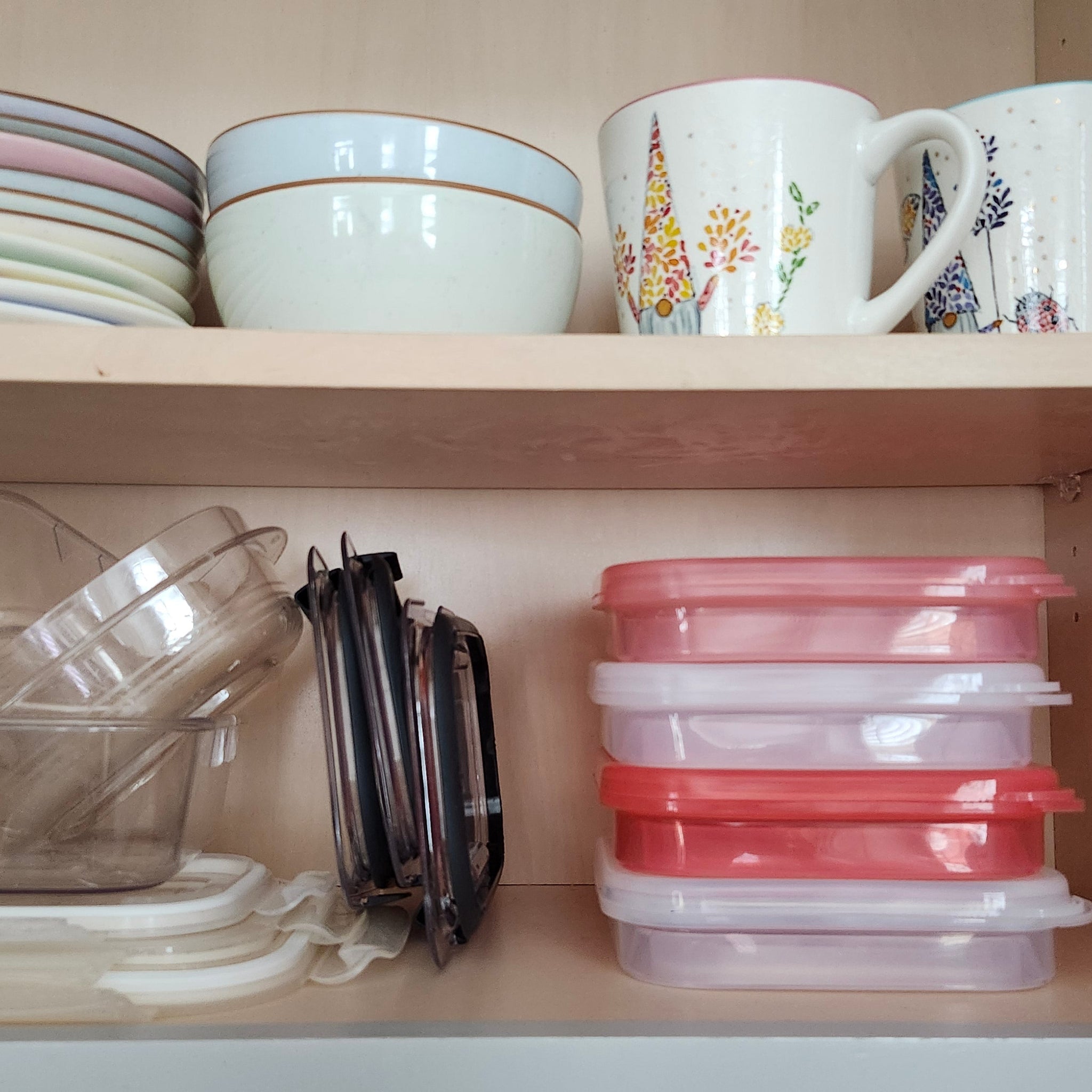 Collapsible food containers neatly stacked beside disorganized plastic food storage with separate lids.