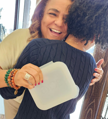 Woman holding a white square object with a blurred background
